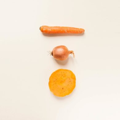 Foto cenital de una zanahoria, una cebolla y media calabaza. Poppyns Magazine