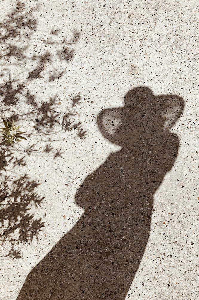 Sombra figura mujer con sombrero y hojas de planta