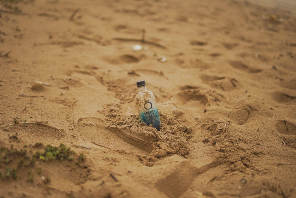 botella de plástico en la arena