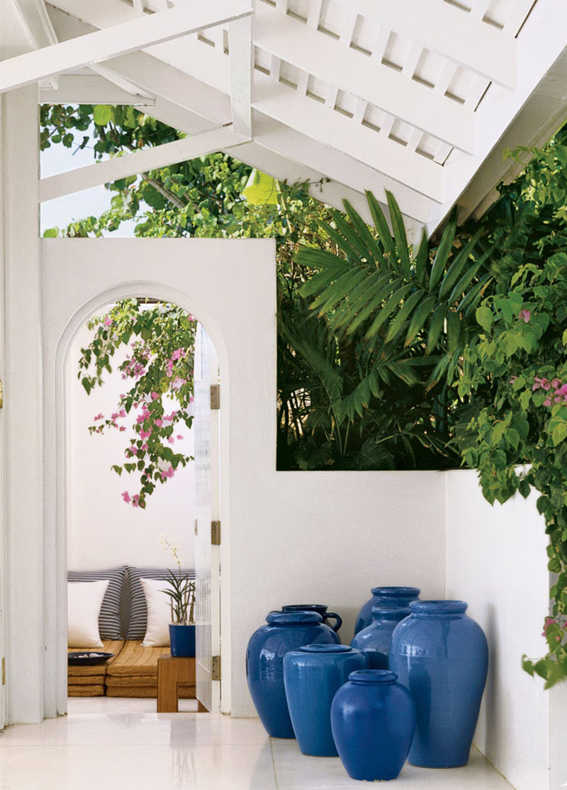 Porche blanco con jarrones azules en mansión Jamaica.