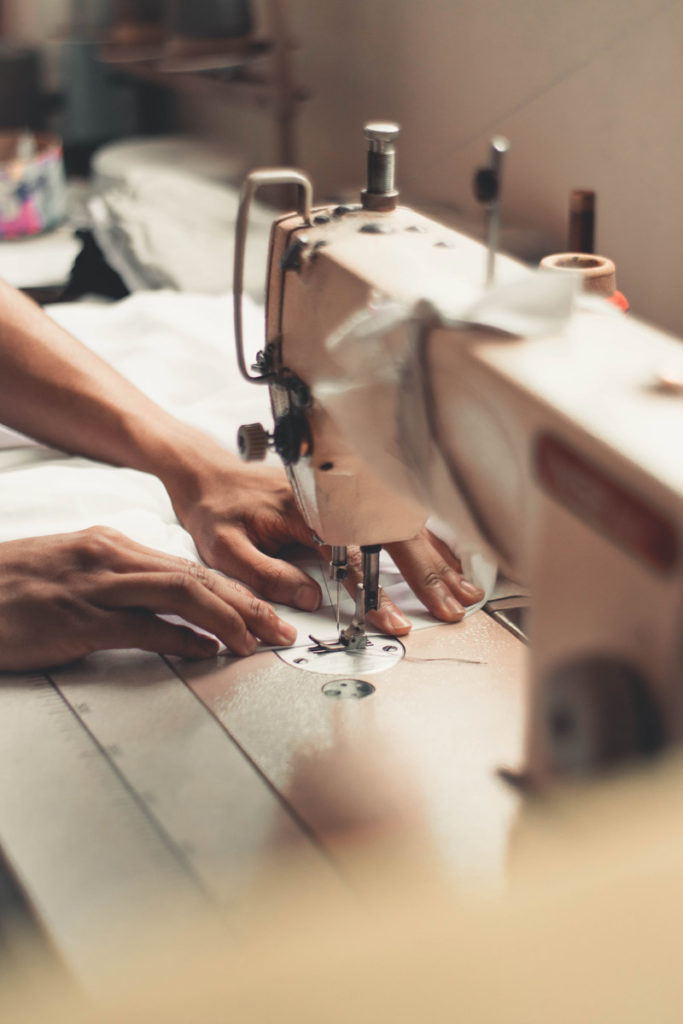 manos trabajando con máquina de costura
